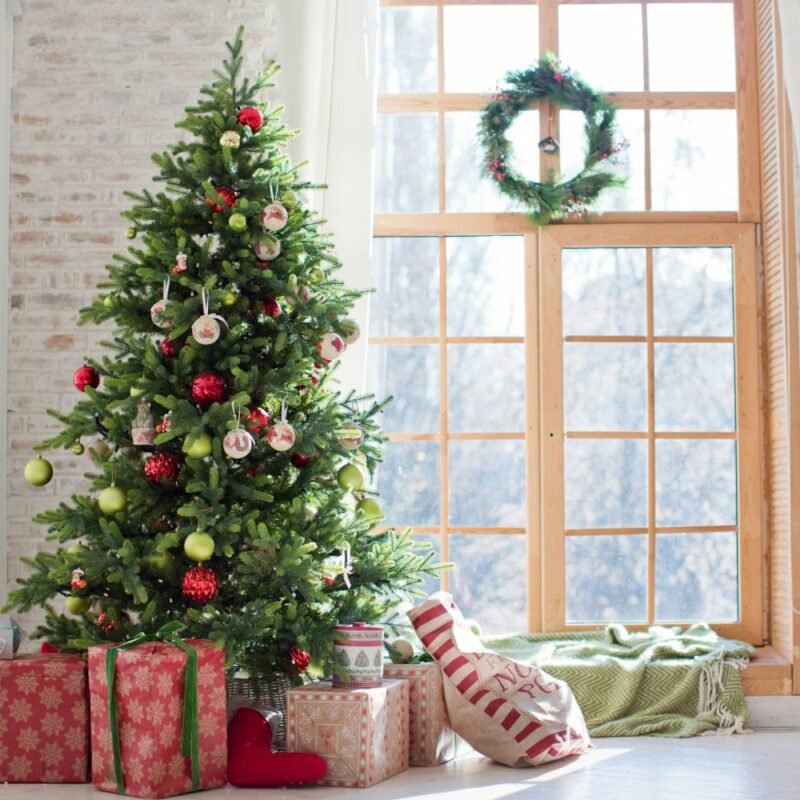 Christmas tree with presents in front of window