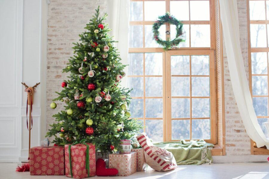 Christmas tree with presents in front of window