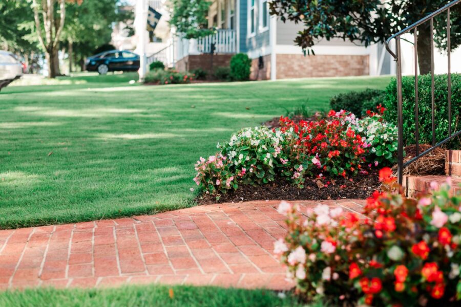 manicured lawn with flowers next to brick steps