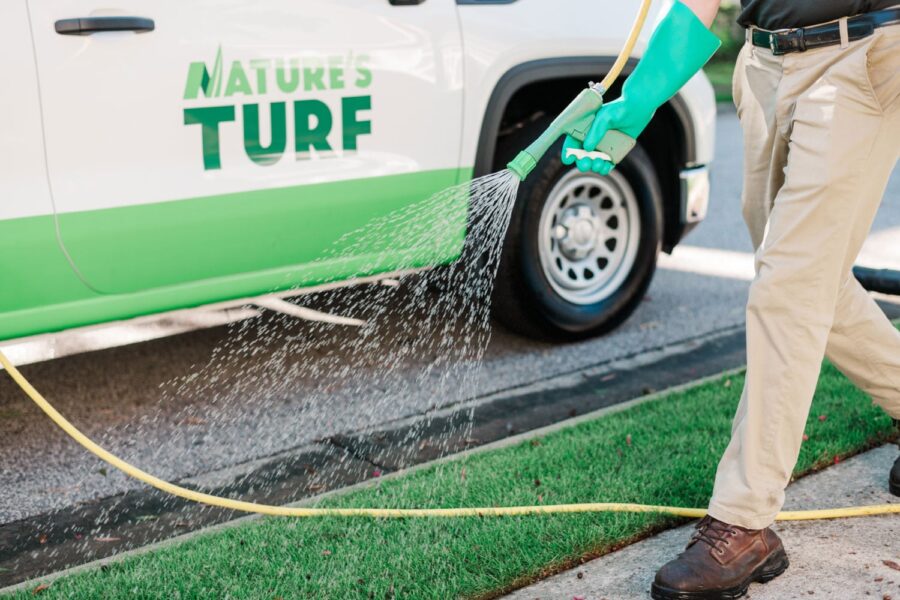 Nature's Turf employee spraying turf